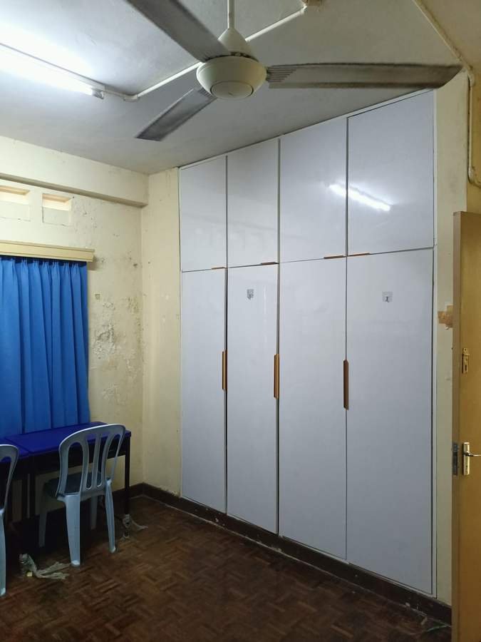 A bedroom in RKS 3 with a wall of white built-in wardrobes and a ceiling fan.